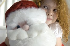 圣诞女孩抱着圣诞老人玩具的小女孩图片