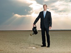 商业图片提着水壶在沙漠中浇水的外国商业男人图片