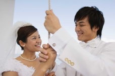 男女礼服面带笑容穿着婚纱礼服手握绳子的男女图片图片