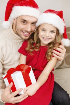 圣诞女孩带着圣诞帽抱着礼物的男人与小女孩图片