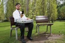 坐在椅子上看手机的男人图片